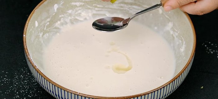 Thêm nước cốt chanh, mè trắng rang và dầu ăn vào bột, khuấy đều và để bột nghỉ 20 phút.