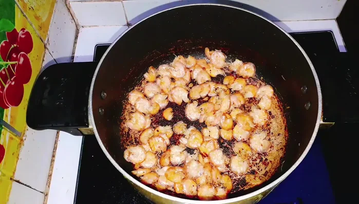 Kết hợp: Cho tôm rang vào chảo, đảo cùng với dừa xào và thịt dừa đã xào. (243.7)