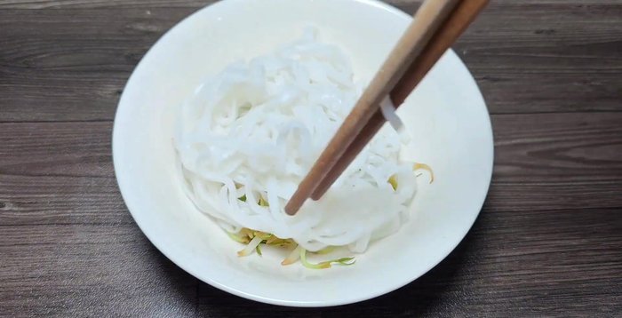 Xếp giá, bánh phở, gà xé hoặc cắt miếng vào tô. Chan nước dùng nóng.