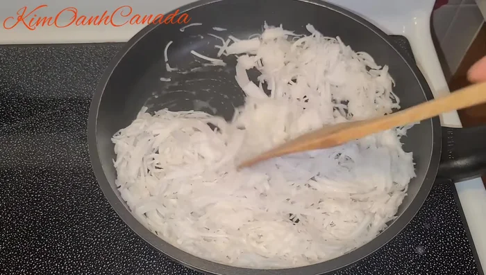 Xào dừa non bào sợi với 3 muỗng canh nước cốt dừa và một chút muối cho đến khi dừa khô lại.