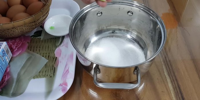 Làm caramel: Cho 150g đường vào nồi, thêm nước cốt chanh và một ít nước, đun nhỏ lửa đến khi đường chuyển màu cánh gián đậm.