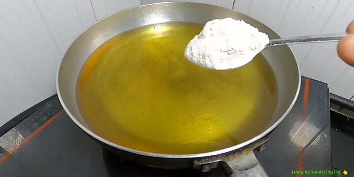 Cho dầu vào chảo, thêm 1 muỗng canh bột mì vào dầu nóng để tránh văng dầu. (233.76)