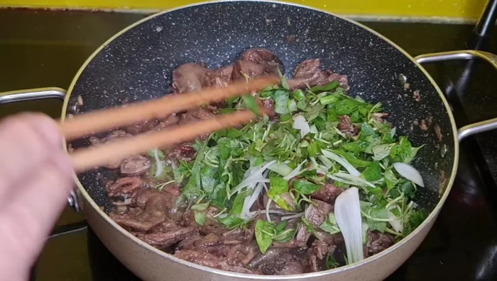 Cho rau răm và hành lá vào đảo đều.